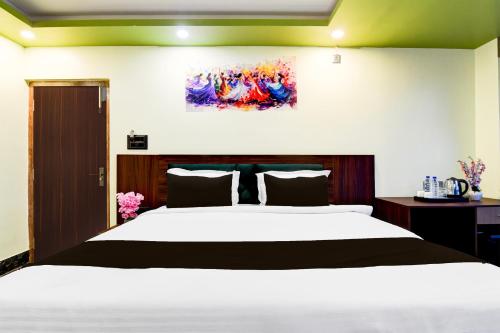 a bedroom with a large bed and a painting on the wall at Super Townhouse AIIMS Kolkata Formerly Tanish Inn in Kalyani