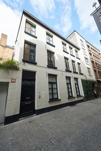Un edificio blanco con una puerta negra en una calle. en B&B Maryline, en Amberes