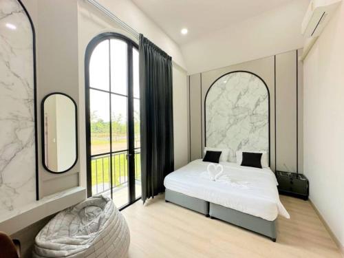a bedroom with a bed and a large window at Nordika Hill in Pak Chong