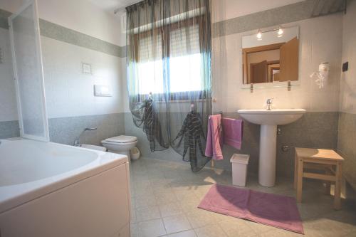 Un baño con lavabo, inodoro y ducha. en Villa Malù, en Citta' Sant'Angelo