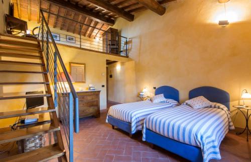 two beds in a room with a staircase at Il Nido di Gabbiano in Scarperia