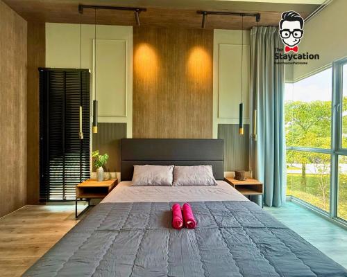 a bedroom with a bed with red shoes on it at Staycation Homestay 76 Liberty Grove Near Airport in Kuching