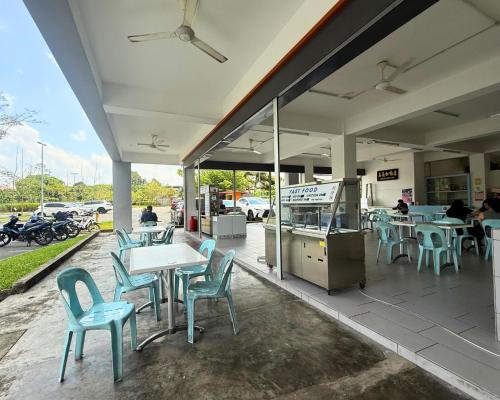 a restaurant with blue chairs and tables on a patio at Staycation Homestay 76 Liberty Grove Near Airport in Kuching