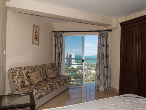 a living room with a couch and a large window at Jomtien Beach Condominium S1 by Olga in Jomtien Beach