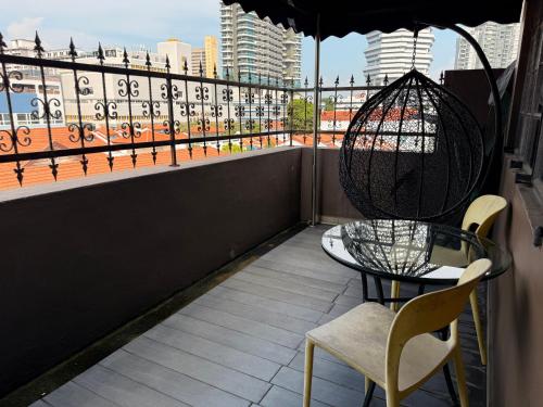 a table and chairs on a balcony with a view at HOTEL JJH Aliwal in Singapore