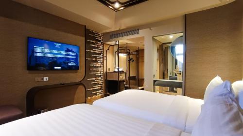 a hotel room with a bed and a flat screen tv at Mercure Surabaya Grand Mirama in Surabaya