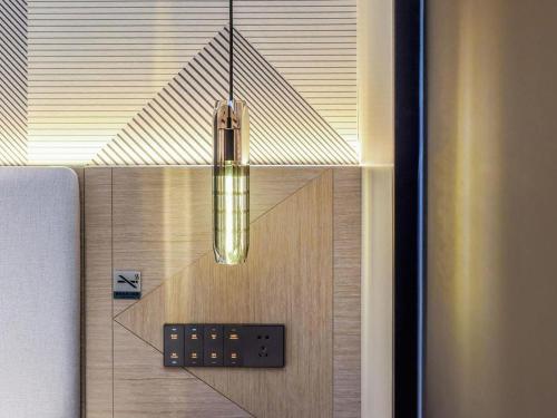 a chandelier hanging from a room with a bed at Borrman Hotel Chongqing Bishan Central Street in Chongqing