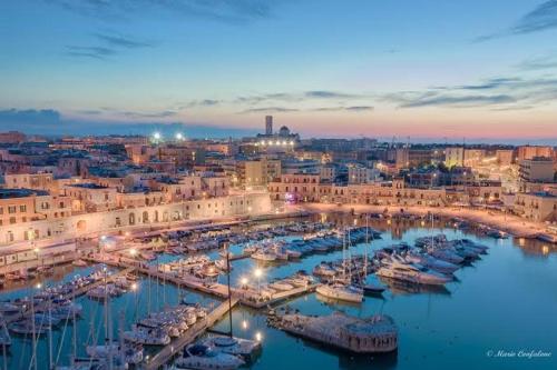 a group of boats docked in a harbor at night at Mura Del Tempo - Historic Residences in Bisceglie