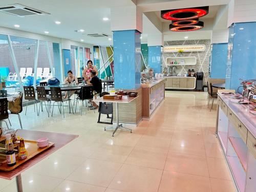 a restaurant with people sitting at tables in a cafeteria at Hotel Kann Pattaya in Pattaya South