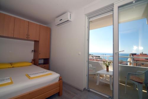 a bedroom with a bed and a view of the ocean at Apartments Ćorić in Baška Voda