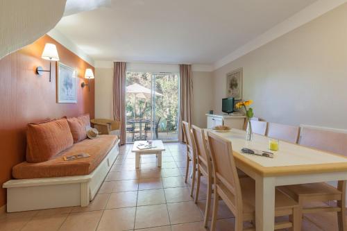 a living room with a couch and a table at Résidence Pierre & Vacances le Hameau de la Pinède in Hyères
