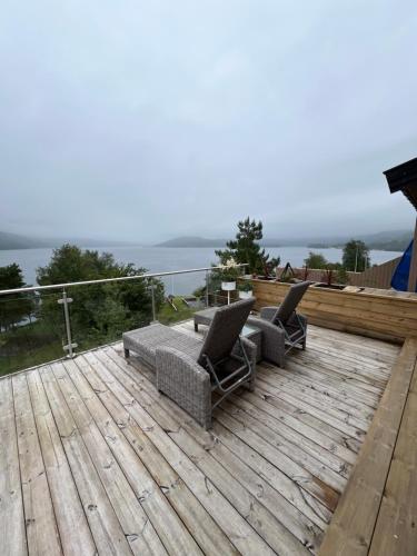 two chairs and a table on a wooden deck at Turer, avslapping, jakt, fiske, utsikt in Etnesjøen
