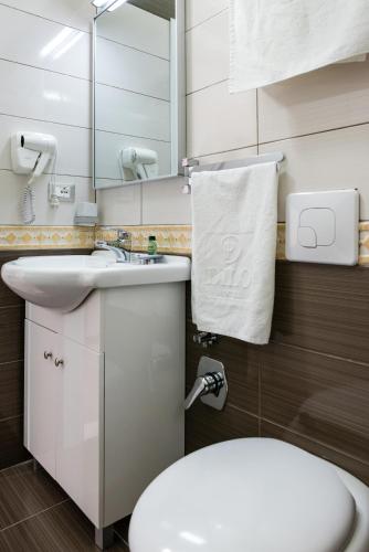 a bathroom with a toilet and a sink and a mirror at KEIT Hotel in Tirana