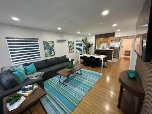 a living room with a blue couch and a kitchen at Coastal Calm Casita in Long Beach