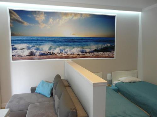 a bedroom with a picture of the ocean on the wall at Apartament Bluesky in Świnoujście