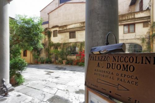 a sign on a pole in front of a building at Palazzo Niccolini al Duomo Residenza D'Epoca in Florence