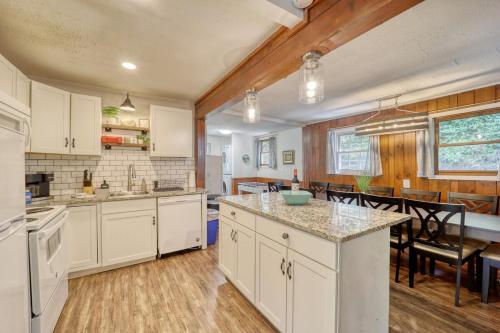 a kitchen with white cabinets and a dining room at Nature Sounds Retreat in Boone