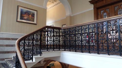 a staircase with a black wrought iron railing at Crown & Mitre Hotel in Carlisle
