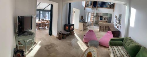 Una sala de estar con un sofá y un televisor. en A l'Orée des Bois, calme et nature, en Villefranche-Sur-Cher