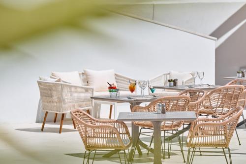 a dining room with wicker chairs and tables at Hotel Ankaa - Adults Only in Porto Cristo