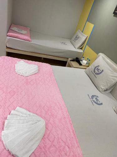 a room with two beds with pink and white sheets at Miracle Gallery Hotel in Makkasan