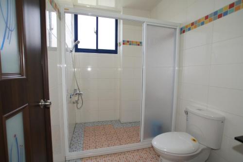a bathroom with a shower and a toilet at Xiang Yang Lan Tian Homestay in Taitung City