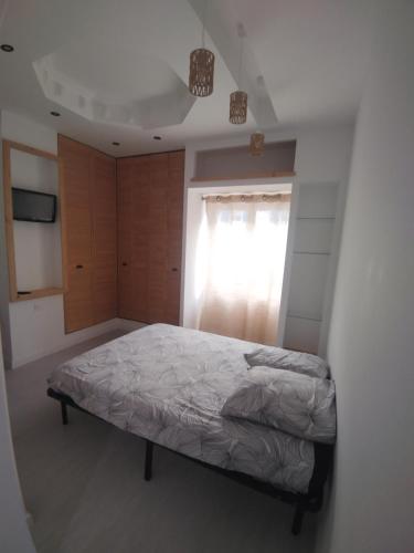 a bedroom with a bed and a window at T1 à 10 min de l' océan in Boucau