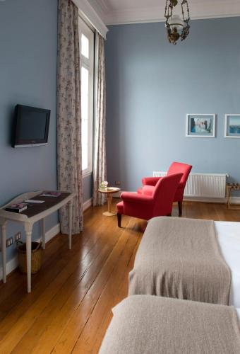 a living room with a red chair and a couch at Zerohotel in Valparaíso
