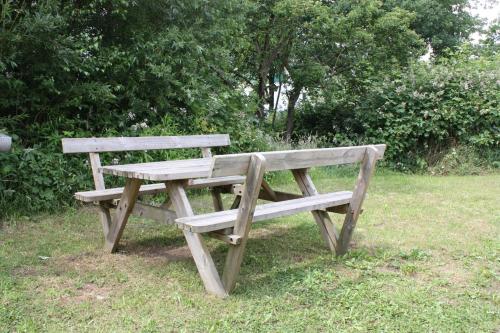 a wooden picnic bench sitting in the grass at Ahoi-Gästehaus in Hamburg