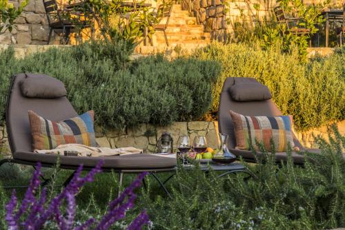 two chairs with a table in a garden with flowers at İda Blue Adatepe in Kucukkuyu