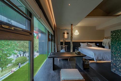 a bedroom with a bed and a desk and a tv at Xi'an Zhiyin Courtyard Designer Hotel in Xi'an