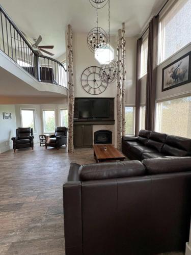 a large living room with a couch and a tv at King Home- Mountain Oasis Pool & Views in Pocatello