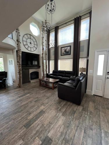 a living room with black leather furniture and a fireplace at King Home- Mountain Oasis Pool & Views in Pocatello