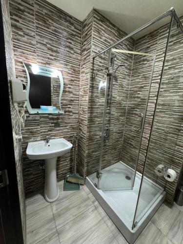 a bathroom with a shower and a sink at Pirosmani Mini Hotel in Batumi