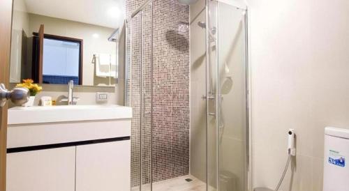 a bathroom with a glass shower and a sink at Green Valley Executive Serviced Residence in Chiang Mai