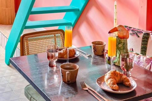 a table with croissants and glasses of orange juice at Palm Royal in Breda