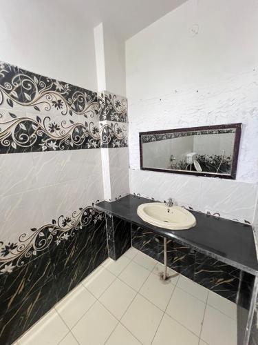 a bathroom with a sink and a mirror at Hotel Satkar Jaisalmer in Jaisalmer