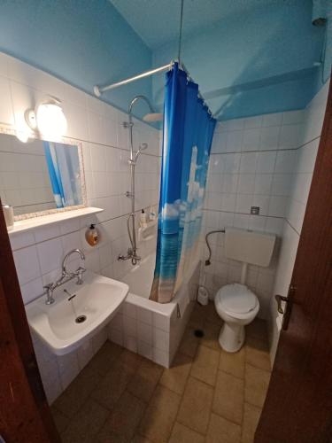 a bathroom with a sink and a toilet and a shower at Lefteri's Rooms in Agia Galini