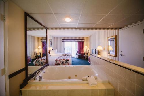 Habitación de hotel con bañera y dormitorio en Bayshore Resort, en Traverse City