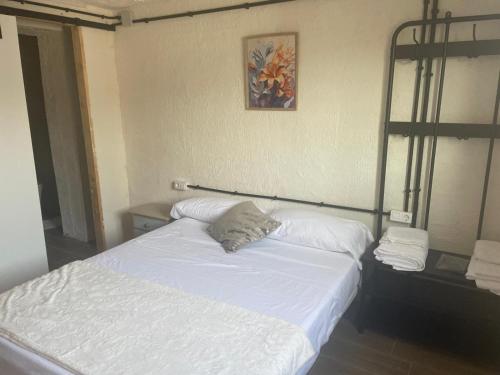 a bedroom with a bed with white sheets and pillows at La Terreta hotel casa rural in El Brosquil