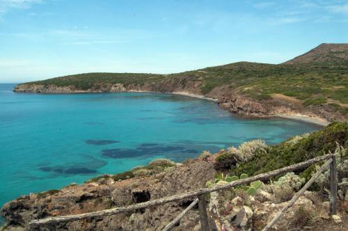 a view of a beach on a hill with the ocean at Domo La Vela - Affittacamere - Living Sant'Antioco in SantʼAntìoco