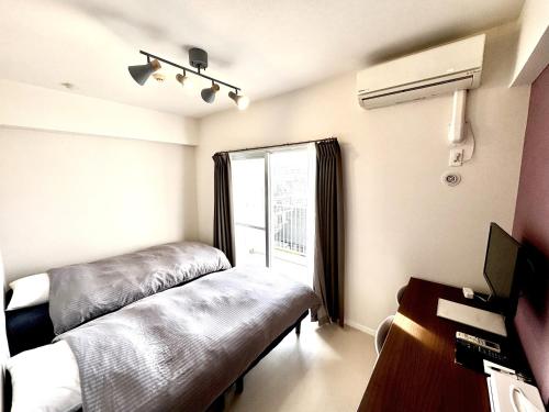 una habitación con dos camas y una ventana en Condominium GOLF GOLF Tsuboya, en Naha