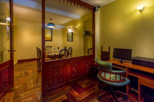 a living room with a desk and a dining room at El Virrey Boutique in Cusco