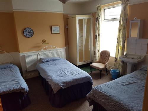 a hotel room with two beds and a sink at Brookfield Guesthouse in Cleethorpes