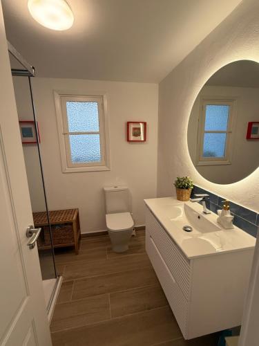 a bathroom with a sink and a toilet and a mirror at Sol, Mar y Terraza XXL frente a la playa in Daimuz