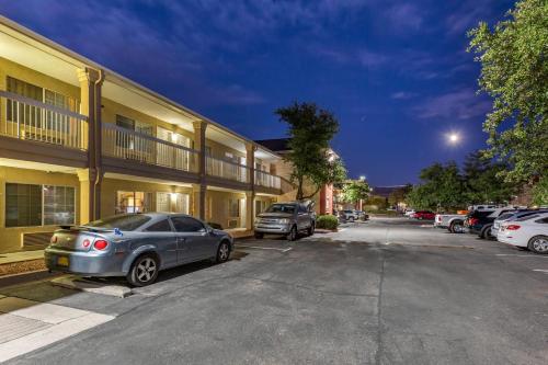 a row of cars parked in front of a building at Suburban Studios Albuquerque Uptown in Albuquerque