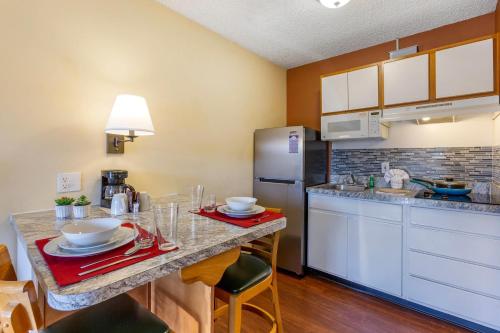 a kitchen with a counter and a refrigerator at Suburban Studios Albuquerque Uptown in Albuquerque