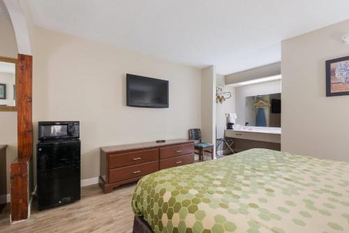 a hotel room with a bed and a tv on the wall at Econo Lodge Inn & Suites Knoxville East in Knoxville