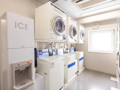 a laundry room with washers and dryers and a window at Comfort Hotel Kurosaki in Kitakyushu