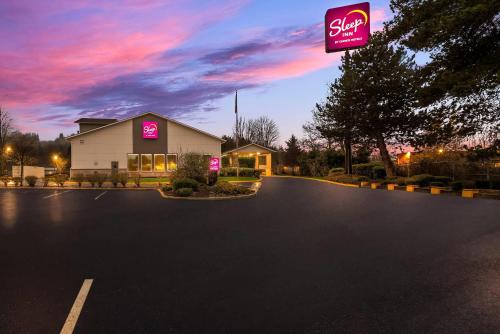 a building with a sign on the side of a parking lot at Sleep Inn Kelso Longview in Kelso